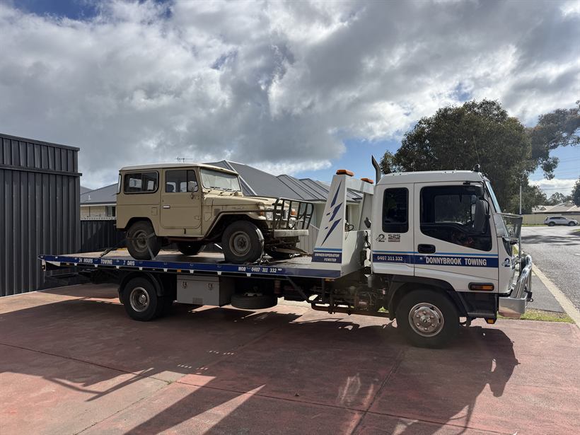Vintage beige FJ40 LandCruiser strapped on the tilt tray